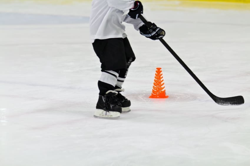 A hockey skater practicing some skating drills on the ice