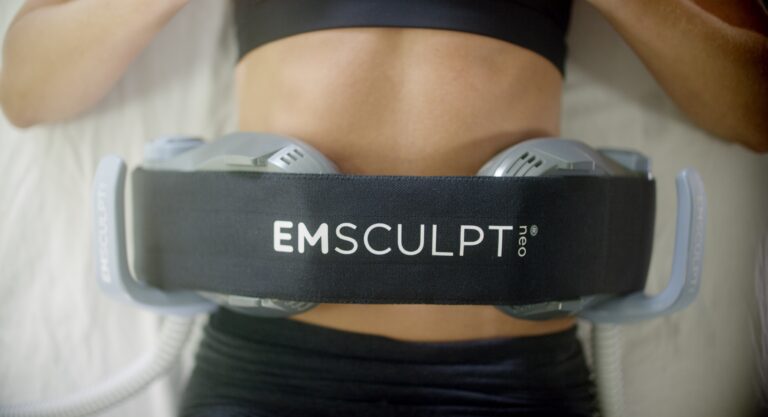 A person using the Emsculpt Neo machine on their abdominal area
